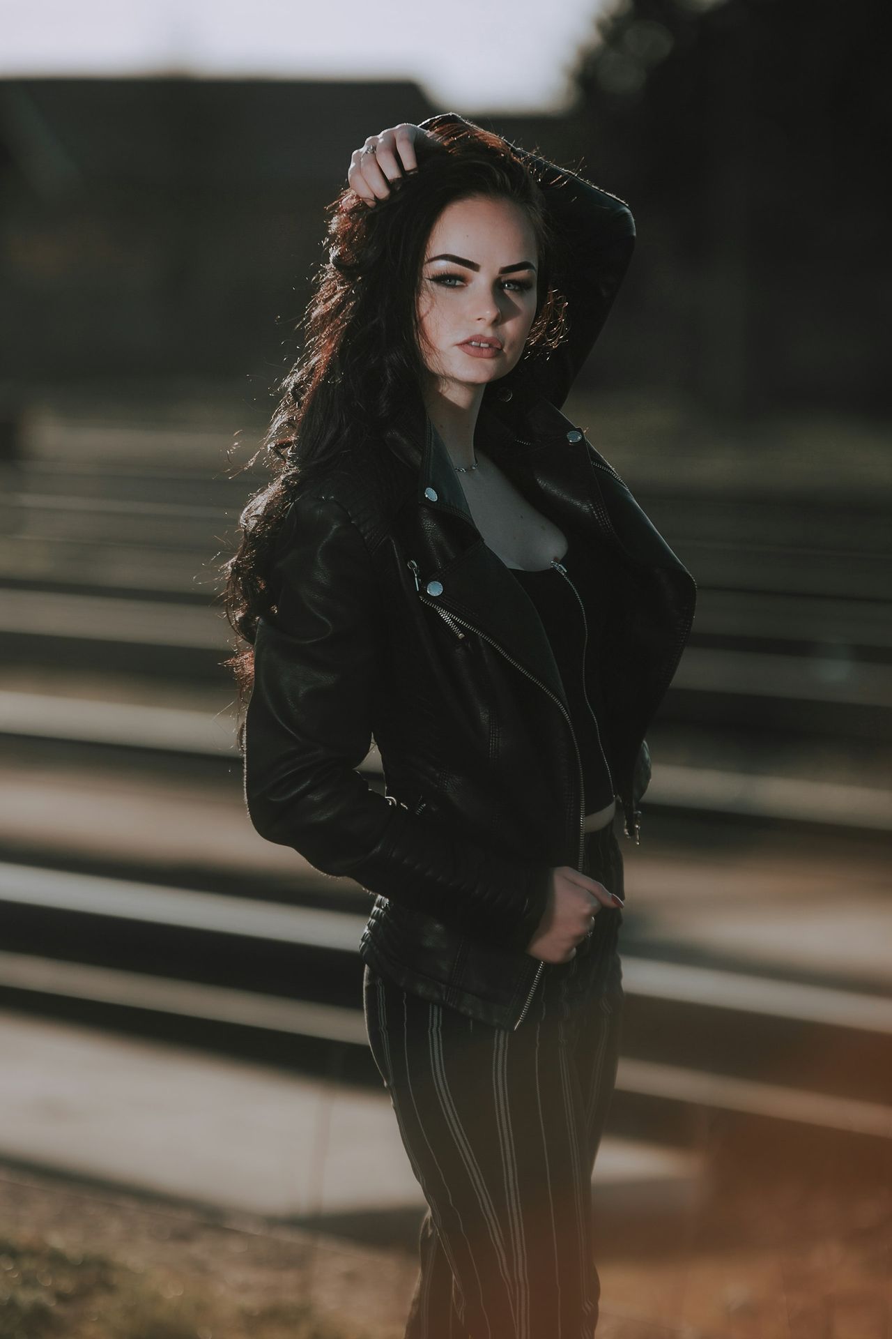 a woman in a black jacket and striped pants